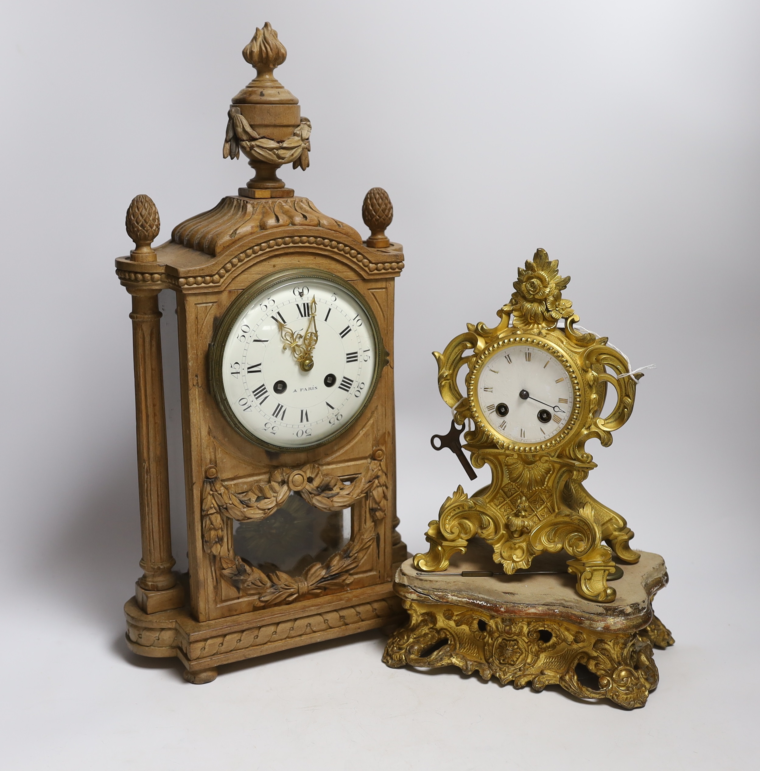 A late 19th century French carved blonde wood mantel clock and similar gilt metal mantel clock. Tallest 45cm